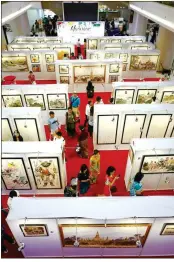  ??  ?? Visitors enjoy paintings by Chinese artists at the exhibition in Yangon.