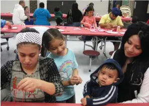  ?? SUBMITTED PHOTOS ?? Johana Gonzalez, Cruz’s daughter, right, holds Estrada while his mother, Gabriela Quiroz, left, works on crafts for him at a Happy Hearts group meeting in the Batesville Parent Center.