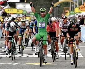  ??  ?? Team Deceuninck's Mark Cavendish (C) celebrates as he crosses the finish line at the end of the tenth stage