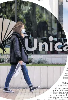  ??  ?? Una mujer pasa ante la sede de Unicaja en Málaga, en diciembre.