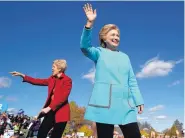  ?? ANDREW HARNIK/ASSOCIATED PRESS ?? Hillary Clinton, right, and Sen. Elizabeth Warren, D-Mass., wave at a rally at St. Anselm College in Manchester, N.H., on Monday.