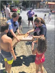  ?? PHOTO COURTESY OF POTTSTOWN POLICE ?? Pottstown Police officer Melinda Beary had lots of takers for the pizza she brought to the open fire hydrant at Chestnut and York streets Wednesday.