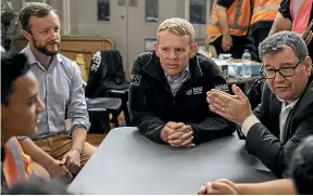  ?? RICKY WILSON/STUFF ?? Prime Minister Chris Hipkins visits an Auckland flood evacuation centre with Finance Minister Grant Robertson, right, and Emergency Management Minister Kieran McAnulty, left.