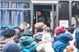  ?? DIEGO HERRERA/XINHUA ?? PEOPLE scramble to board a bus in Irpin, Ukraine. Ukrainians are fleeing to safer grounds amid the Russian invasion of their country.