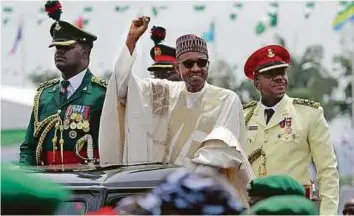  ?? AFP ?? Controvers­ial campaign Members of Nigeria’s opposition People’s Democratic Party accuse President Buhari (centre) of carrying out a vendetta against them under the guise of an anti-corruption drive.