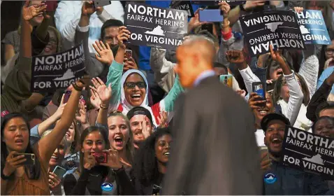  ??  ?? Northam supporters cheering Obama as he takes to the stage during a campaign rally in Richmond. — AFP