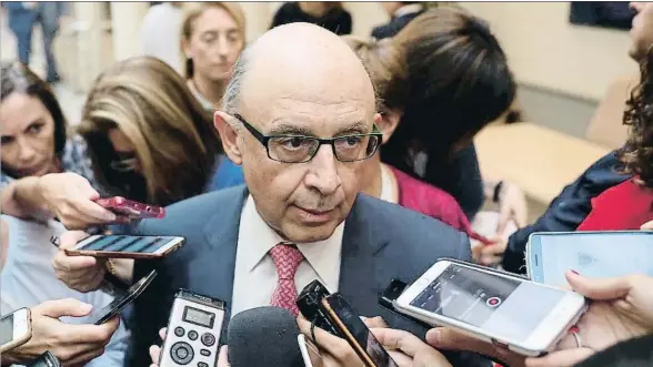  ?? CHEMA MOYA / EFE ?? Cristóbal Montoro en los pasillos del Senado respondien­do a la prensa