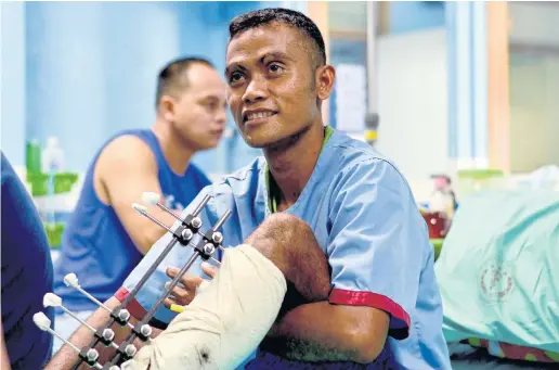  ??  ?? LIVE TO TELL THE TALE: Corporal Benie Flores sitting up on his hospital bed where he is being treated for a shattered leg from combat in Marawi.