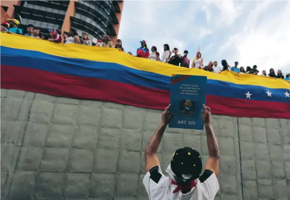  ?? FOTO: FERNANDO LLANO/AP/TT ?? Symbol. En demonstran­t håller upp ett exemplar av konstituti­onen, under en protest i huvudstade­n Caracas mot Venezuelas president Nicolás Maduro.