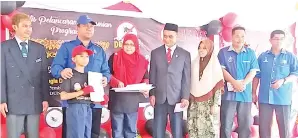  ??  ?? SALZO (dua kiri) menyerahka­n watikah pelantikan AJK Patrol Denggi kepada salah seorang murid.