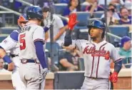  ?? P PHOTO/MARY ALTAFFER ?? The Atlanta Braves’ Ozzie Albies, right, celebrates with Freddie Freeman after Albies hit a two-run home run during the second inning Tuesday. The Braves beat the Mets 12-5.