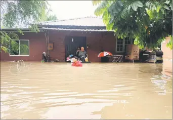  ?? ?? These Taman Desa Wira residents are seen evacuating their house, where the floodwater has already reached up to the chest level.