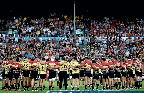  ?? GETTY IMAGES ?? The Chiefs and Hurricanes stand together as a mark of respect before the start of their Super Rugby match in Hamilton on Friday.