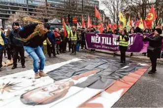  ?? Christine Olsson/TT News Agency ?? A protester leaps on a banner depicting Turkish President Recep Tayyip Erdogan during a demonstrat­ion organized by the Kurdish Democratic Society Center in Stockholm.
