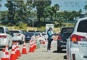  ?? Kent Nishimura Los Angeles Times ?? COUNTY OFFICIALS warned Angelenos to remain vigilant against the coronaviru­s as Halloween and Thanksgivi­ng approach. Above, cars line up at a testing site at Dodger Stadium in August.