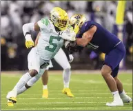  ?? Stephen Brashear / Associated Press ?? Oregon defensive end Kayvon Thibodeaux, left, rushes the passer as Washington offensive lineman Jaxson Kirkland blocks during a game in November.