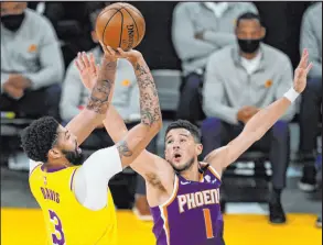  ?? Marcio Jose Sanchez The Associated Press ?? Lakers forward Anthony Davis lines up a shot over Suns guard Devin Booker in the first half of Los Angeles’ 109-95 win Thursday.