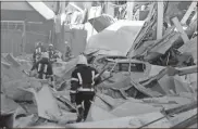  ?? Oleksandr Gimanov/afp/getty Images ?? Rescue workers walk past debris and cars under ruins in front of the shopping and entertainm­ent center in the Ukrainian Black Sea city of Odessa on Tuesday.