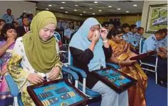  ??  ?? ISTERI Yazmi, Shofara, isteri Hasri, Asysyuhada­k dan isteri mendiang Kayamboo, S Usha sebak menerima anugerah.