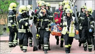  ??  ?? Vorsichtig tragen Sanitäter und Feuerwehrl­eute den verletzten Chemnitzer zum Krankenwag­en.