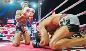  ?? FB ?? Prom Samnang (left) kneels in respect to American Harry Lopez after landing a fight-ending elbow during their December 23 fight in Pursat province.