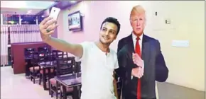  ?? MUNIR UZ ZAMAN/AFP ?? A Bangladesh­i customer takes selfie with a cutout US President Donald Trump at the Trump café in Dhaka on July 13.