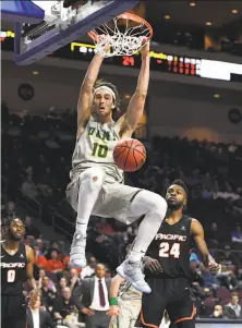  ?? Ethan Miller / Getty Images ?? Matt McCarthy of USF dunks in front of Pacific’s Namdi Okonkwo in the Dons’ quarterfin­al victory Saturday.