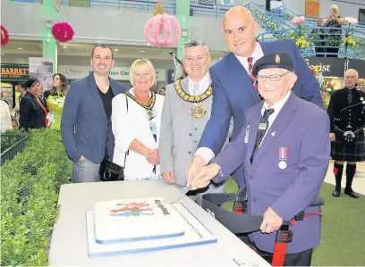  ??  ?? Hundreds of shoppers and community groups enjoyed a fun-packed celebratio­n at Runcorn Shopping City as it went back to the future to mark its new name. Cutting the celebratio­n cake are, from left: John Saunders, who designed the new Runcorn Shopping...