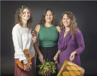  ?? (NWA Democrat-Gazette/Spencer Tirey) ?? Woven is (from left) Jessica Hawk with her ukulele, Talina Madonna with her leaves and Regina Caeli with her spirit drum. The Fayettevil­le-based musical trio stopped by the Northwest Arkansas Democrat-Gazette podcast studio for an interview and to perform their songs, “Take Your Troubles Down to the River,” “Dwelling Space” and “New Day.”