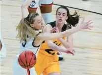  ?? ERIC GAY/AP ?? Iowa’s Caitlin Clark passes the ball as she’s guarded by Uconn’s Paige Bueckers in a Sweet 16 game in 2021..