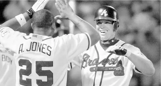  ?? ALAN MOTHNER/ASSOCIATED PRESS ?? Atlanta Braves 3rd baseman Chipper Jones, right, celebrates with Andruw Jones after hitting a grand slam against the Marlins in 2001. Jones is a native of Pierson in Volusia County.