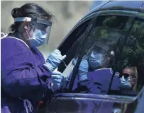  ?? CLIFFORD SKARSTEDT EXAMINER ?? Workers test people for COVID-19 who don't have symptoms at a drive-thru at Douro Community Centre on Tuesday.