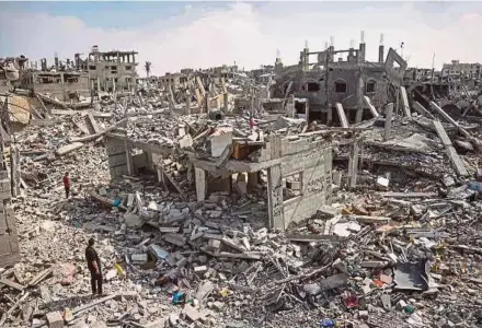  ?? AFP PIC ?? People inspecting the damage caused by an Israeli bombardmen­t in Khan Younis, in the southern Gaza Strip, on Tuesday.