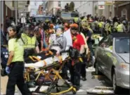  ?? STEVE HELBER / ASSOCIATED PRESS ?? Rescue personnel help injured people after a car ran into a large group of protesters after a white nationalis­t rally in Charlottes­ville, Va., Saturday.