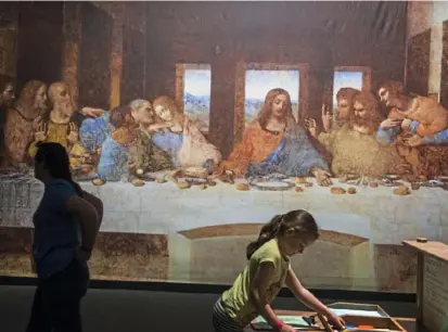  ?? Lake Fong/Post-Gazette ?? Addison Baker, 6, of Bear, 6, of Beaver picks a crayon for coloring while her mom, Amy, looks at the replica of Leonardo da Vinci’s painting “The Last Suppe Last Supper.” See video at post-gazette.com.