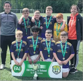  ?? ?? RIGHT: Mr Kieran Scanlon and Ms Aoife Neville with the Ballylooby NS team after winning the Munster Cup in the FAI Primary School 5s competitio­n.