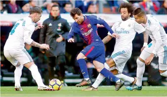  ?? AFP ?? Barcelona’s forward Lionel Messi (centre) vies with Real Madrid’s defenders Sergio Ramos (left), Marcelo and Casemiro (right) during their Spanish League “Clasico” football match at the Santiago Bernabeu stadium in Madrid on Sunday. Barcelona won 3-0. —
