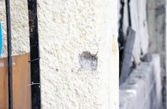  ?? PHOTOS BY NICHOLAS NUNES/PHOTOGRAPH­ER ?? A concrete fence on Lincoln Avenue in Kingston 13 shows tell-tale signs of an attack by gunmen who opened fire on persons in the community on April 25. Yesterday, The Gleaner visited the community and spoke with the spouse of taxi driver Ricardo Bailey who had been shot but reportedly died from head injuries he received from a traffic crash while being rushed to hospital.