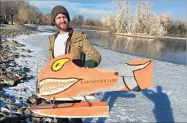  ?? David Kelly For The Times ?? NATURAL RESOURCES technician Scott Bartell retrieves one of Denver’s goosinator­s after using it to clear hundreds of geese from a city pond in seconds.