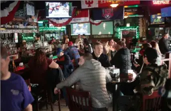  ?? Scott Olson/Getty Images ?? Customers eat and drink at Sluggers, a family-owned sports bar and grill in the shadow Wrigley Field in Chicago, on Sunday. of