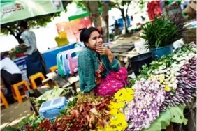  ??  ?? 早市上有很多卖花的摊­位。花卉品种有玫瑰、百合，以及各种大小菊花。缅甸将近6000万的­人口中，信仰佛教的大约占85%，人们有用鲜花供奉佛像­的习俗。