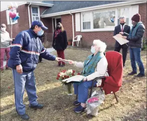  ?? Tyler Sizemore / Hearst Connecticu­t Media ?? Letter carrier Victor Aguilar delivers Marie Bologna D’Elia her birthday card on her 100th birthday on the front lawn of her home in Greenwich on Tuesday. D’Elia’s family surprised her on her birthday with a drive-thru parade from the Greenwich Women’s Club, of which D’Elia is a member, and a party on her front lawn with friends, family, and former colleagues.