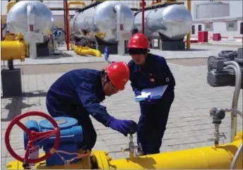  ?? XINHUA ?? China National Petroleum Corp technical employees check facilities at Qinghai oilfield.