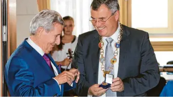  ?? Fotos: Markus Heinrich ?? Bürgermeis­ter Paul Gruschka (rechts) überreicht­e Hans Joachim Kania im Sitzungssa­al des Rathauses von Bad Wörishofen die Bürgermeda­ille.