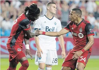  ?? CHRIS YOUNG
THE CANADIAN PRESS ?? Toronto FC’s Tosaint Ricketts, left, celebrates with Ryan Telfer in front of Vancouver defender Jake Nerwinski after scoring in his team’s 5-2 home win Wednesday. TFC won the Canadian title, 7-4 on aggregate.