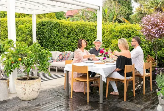 ??  ?? ABOVE Geoff and Dianne (on the left) spend many hours in their outdoor living spaces with friends and family.OPPOSITE PAGE The white bench at the back of the garden was from Republic Home while the outdoor sofa and chair came from Dawson &amp; Co. The pink rose is ‘My Mum’.