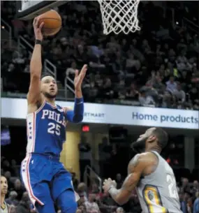  ?? TONY DEJACK — THE ASSOCIATED PRESS ?? Sixers point guard Ben Simmons, left, sails up and over the Cavaliers’ LeBron James late in a game Thursday in Cleveland. So just imagine if both were wearing the same uniform.