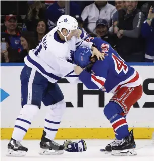  ?? BRUCE BENNETT GETTY IMAGES ?? Leafs forward Zach Hyman, left, and the Rangers’ Neal Pionk drop the gloves for a rare scrap during Sunday’s game at Madison Square Garden in New York.