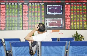  ?? — Reuters photo ?? An investor sits in front of an electronic board showing stock informatio­n at a brokerage house in Fuyang, Anhui province, China. China will allow foreign investors direct access to its massive bond market starting today, the Chinese central bank said.