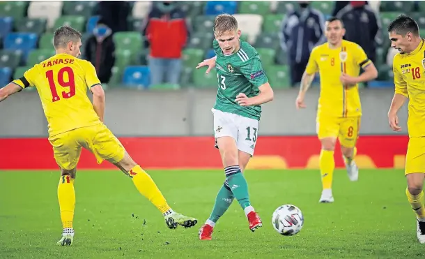  ??  ?? INTERNATIO­NAL SAINT: Northern Ireland’s Ali McCann is tracked by Romania’s Florin Tanase and Razvan Marin earlier this week.